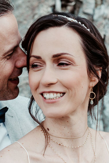 Nahaufnahme des Brautpaares, auf der Brautfrisur, Brautschmuck und Make-up gut zu sehen sind.