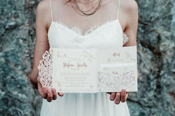 Braut hält ihre Hochzeitseinladung